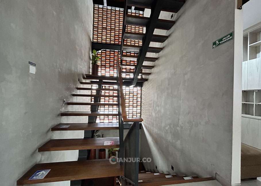Tangga antar lantai dengan aksen kayu - Klinik Keluarga Cianjur